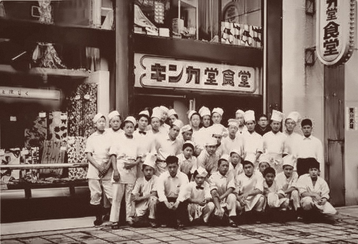 キンカ堂食堂の前に並ぶ職人たちの記念写真